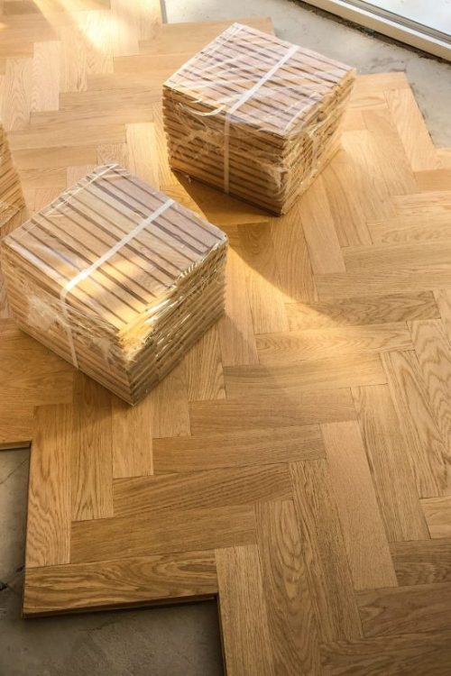 packs-of-wooden-parquet-flooring-are-seen-during-installation-of-wood-herringbone-kitchen-floor.jpg